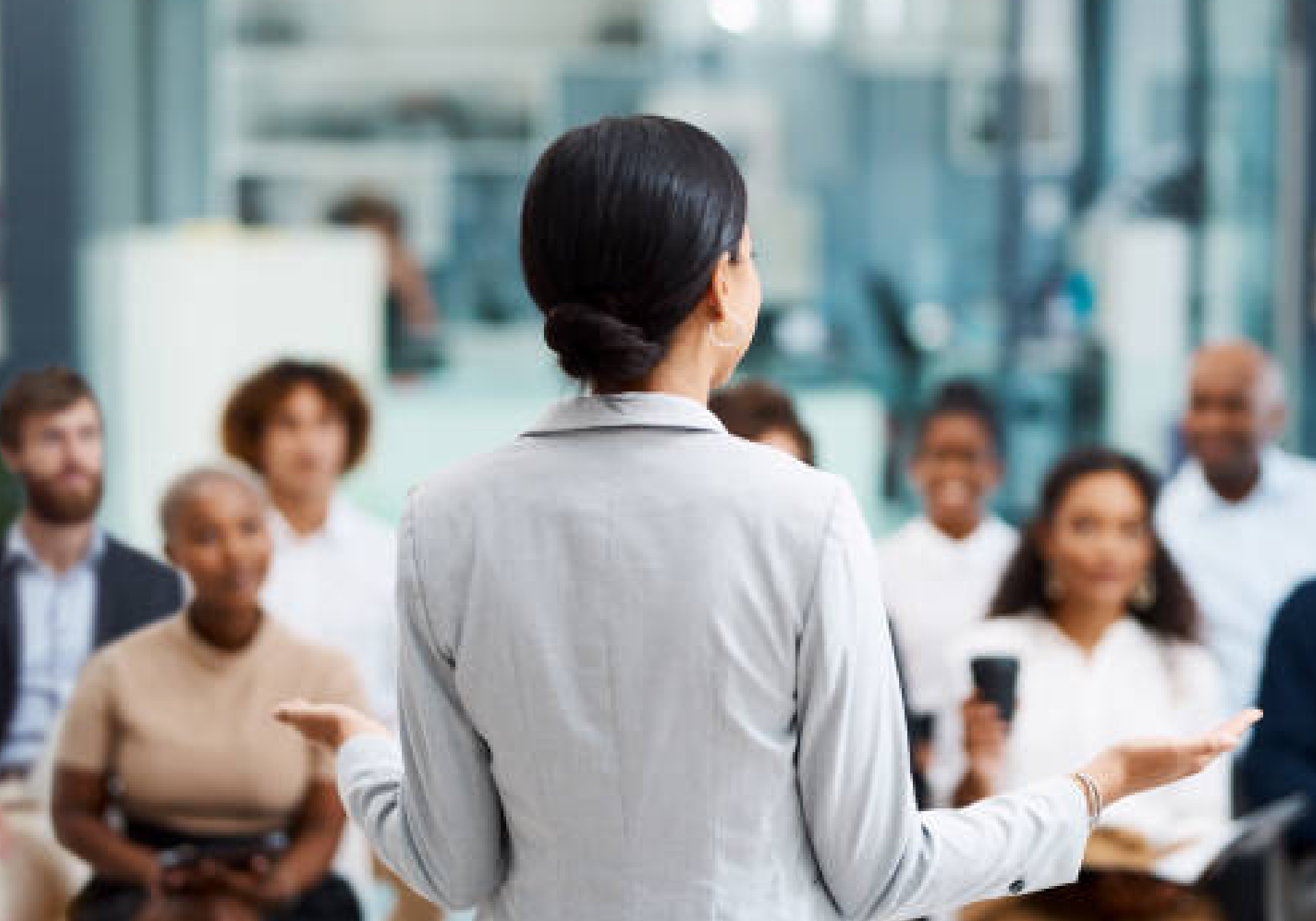 A phtoto with women sitting in a conference room at a table in a business meeting